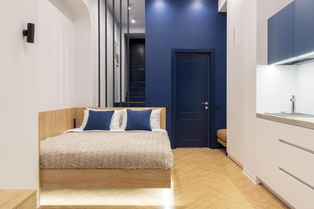 1 dormitorio con cama y pared azul en Main Square, en Leópolis