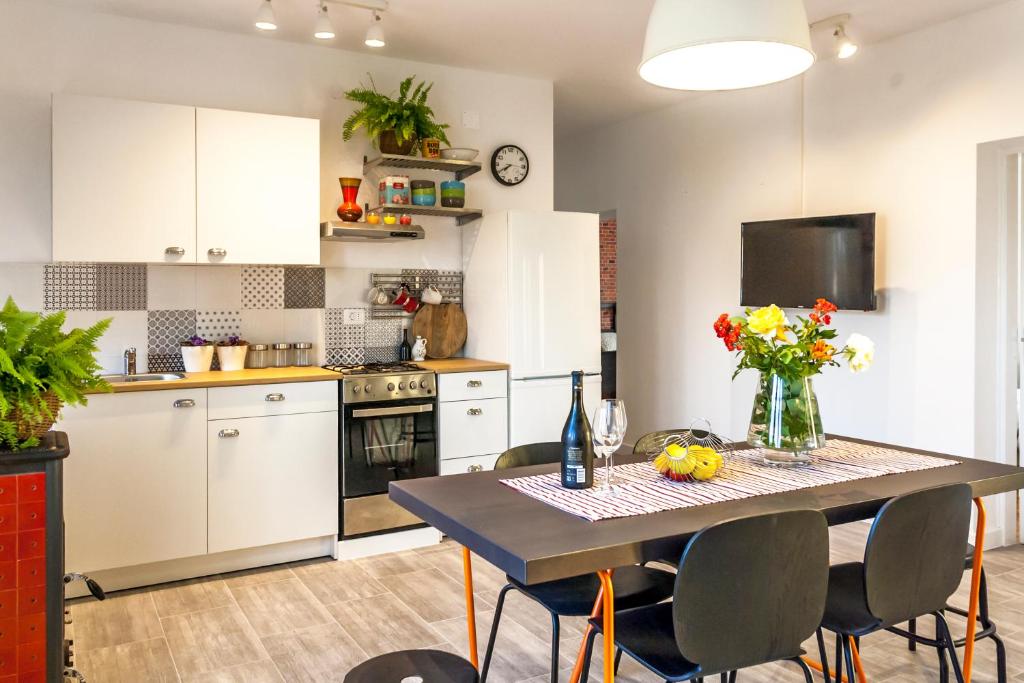 a kitchen with a table and chairs and a kitchen with white cabinets at Angelina's garden place, max 6 persons, near Pula in Marčana