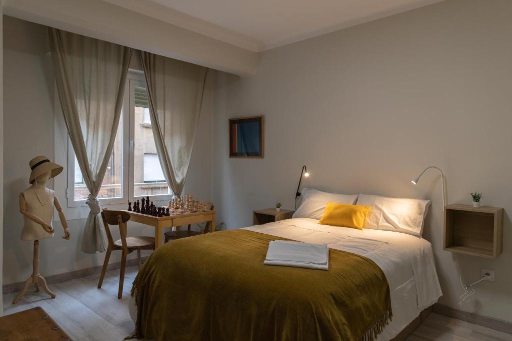 a bedroom with a bed and a table and a window at Apartamento Vara de Rey in Logroño