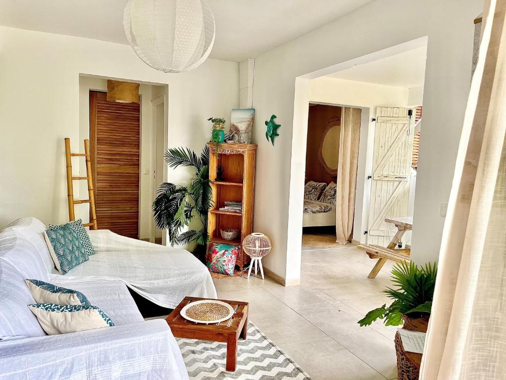 a living room with a white couch and a table at Ti Kay Ilets in Les Trois-Îlets