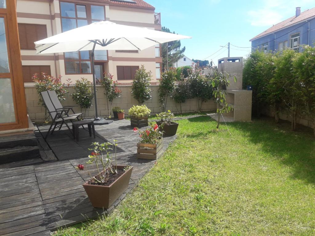 a patio with an umbrella and some potted plants at Apartamento con jardín in Lira