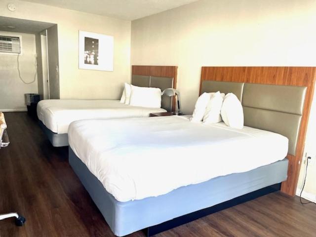 2 camas en una habitación de hotel con sábanas blancas en Mystic Sea en Myrtle Beach