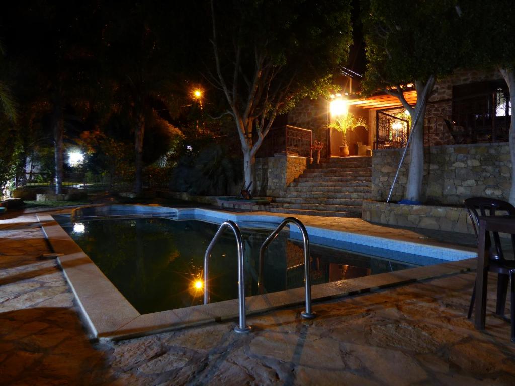 Agadir-Taghazout Magnifique Villa Dar Lina 4 etoiles في أغادير: وجود مسبح في الليل مع وجود بعض الاضاءات فيه