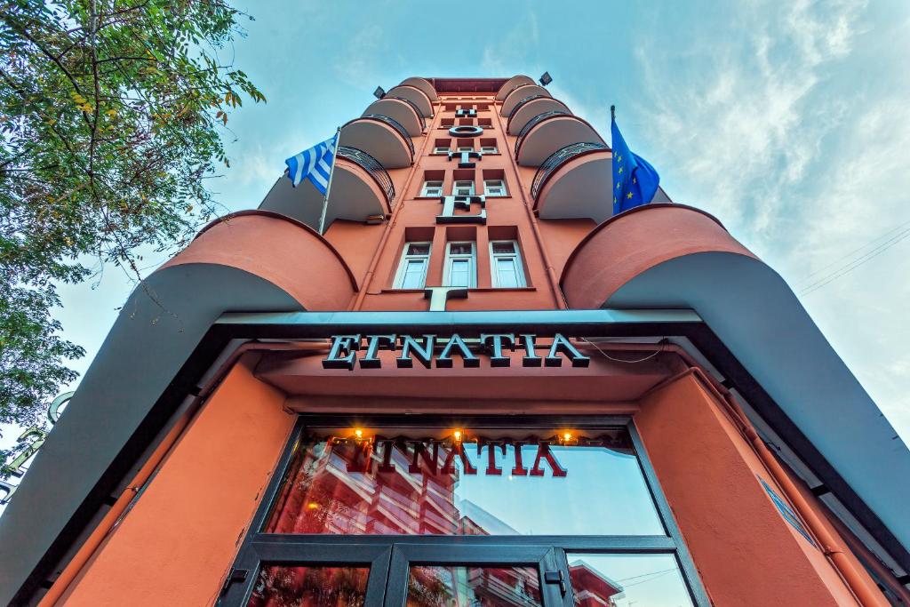 Un edificio alto de color naranja con un letrero. en Egnatia Hotel, en Tesalónica