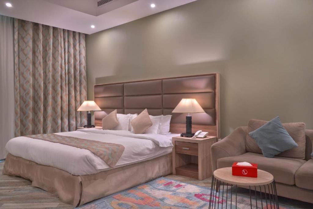 sypialnia z dużym łóżkiem i kanapą w obiekcie فندق مروج نجد w mieście Dżudda