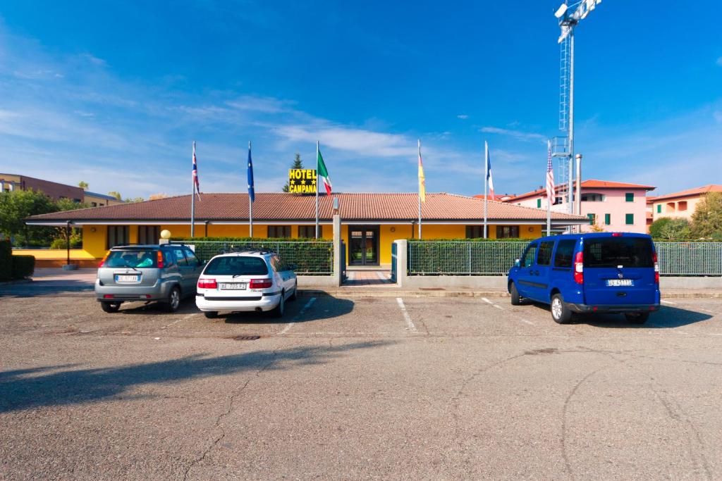 tres autos estacionados en un estacionamiento frente a un edificio en Hotel Campana, en Reggio Emilia