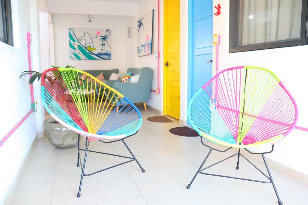 two colorful chairs sitting in a room at Hotel Casa Mandarine , Amazing Private Rooms w Balcony, Rooftop, Hammocks, AC, SmarTV, 100mbs! in Zihuatanejo