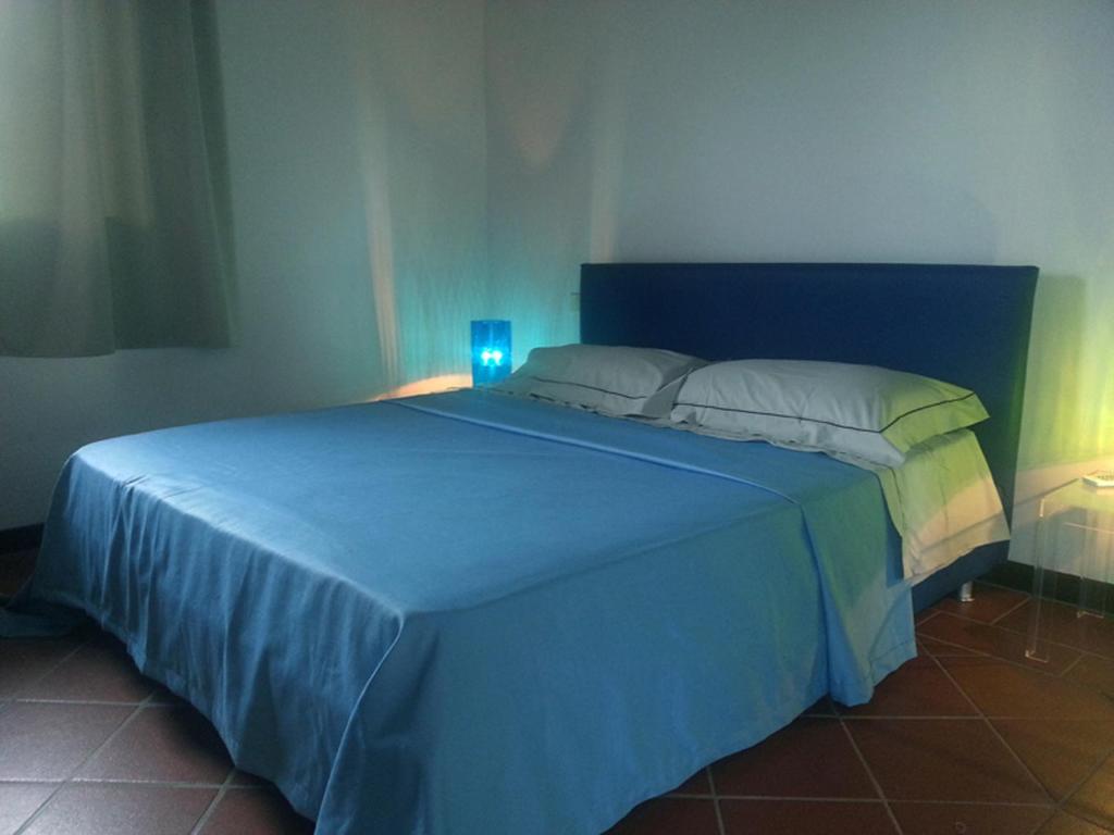 a blue bed in a bedroom with a blue light at Villa Picasso A in Stintino