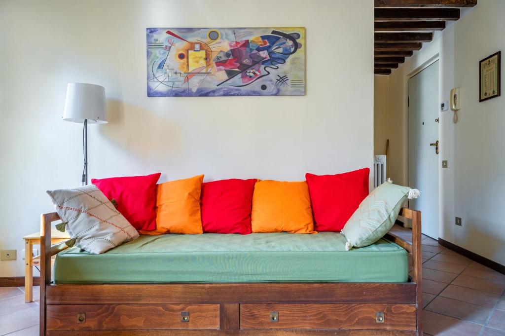 Historic Center Functional Apartment في بارما: أريكة مع وسائد ملونة في الغرفة
