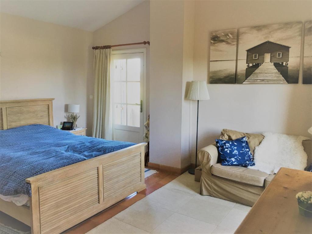 a bedroom with a bed and a couch at la maison des Olivettes in Uzès