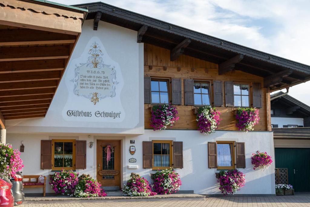 ein Gebäude mit Blumen davor in der Unterkunft Gästehaus Schwaiger - Wiesenweg in Kössen