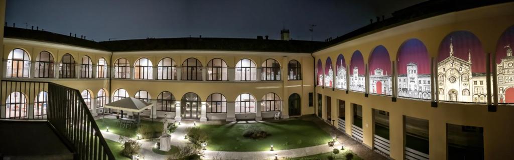 ein großes Gebäude mit einem Innenhof mit Beleuchtung in der Unterkunft CallMe Crema - Struttura in centro storico in Crema