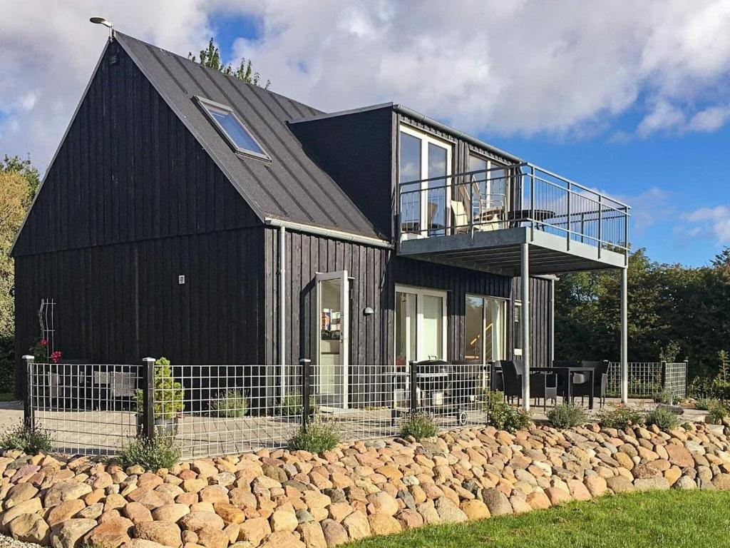 a black house with a black roof and a balcony at Luxury Spa Retreat by Sea in Humble