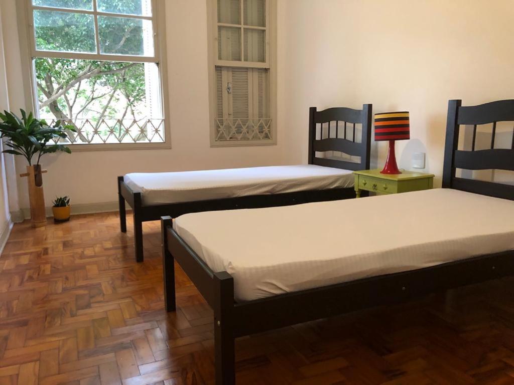 een kamer met 2 bedden en een raam bij Apartamento Liberdade in Sao Paulo