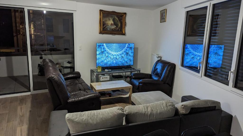 ein Wohnzimmer mit einem Sofa, 2 Stühlen und einem TV in der Unterkunft Chambre dans appartement près du Roazhon Park in Rennes