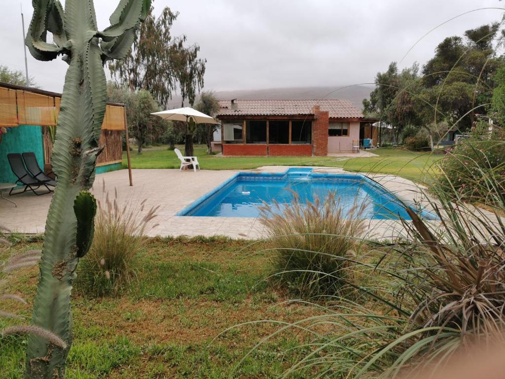 a swimming pool in a yard next to a house at Parcela Del Desierto in Copiapó