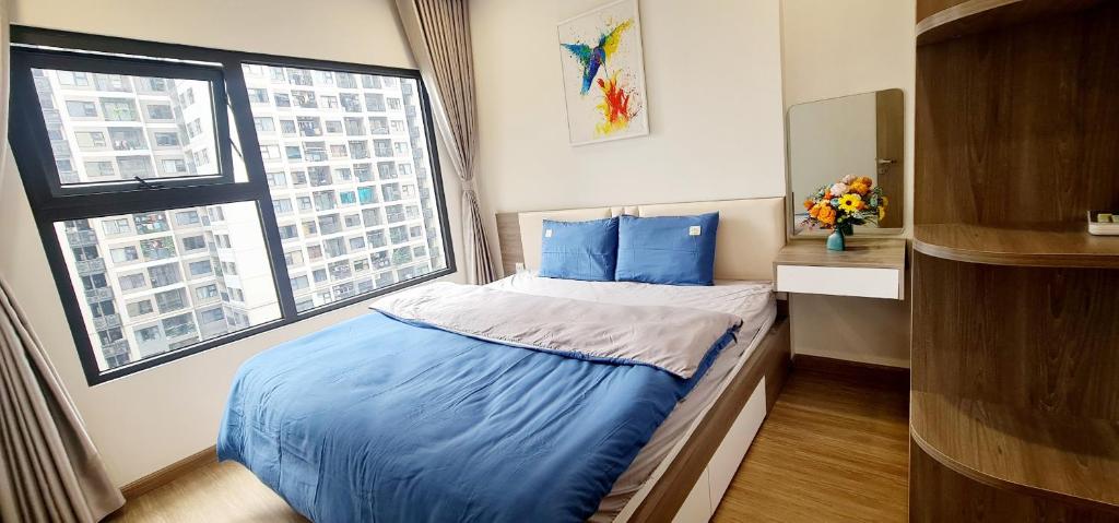 ein Schlafzimmer mit einem Bett mit blauen Laken und einem Fenster in der Unterkunft NK#Homestay#Vinhomes#Oceanpark#2PN#C22 in Gia Lâm Pho