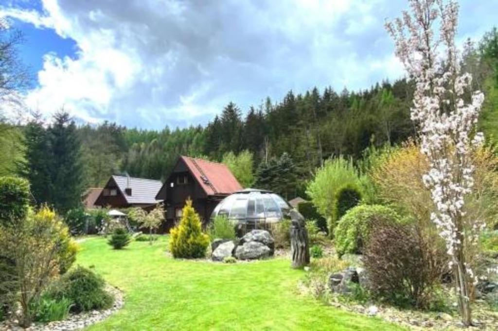 a garden with a greenhouse in the middle of a yard at Charming cottage KLARA with Sauna, Nature&Privacy near Prague in Malé Kyšice