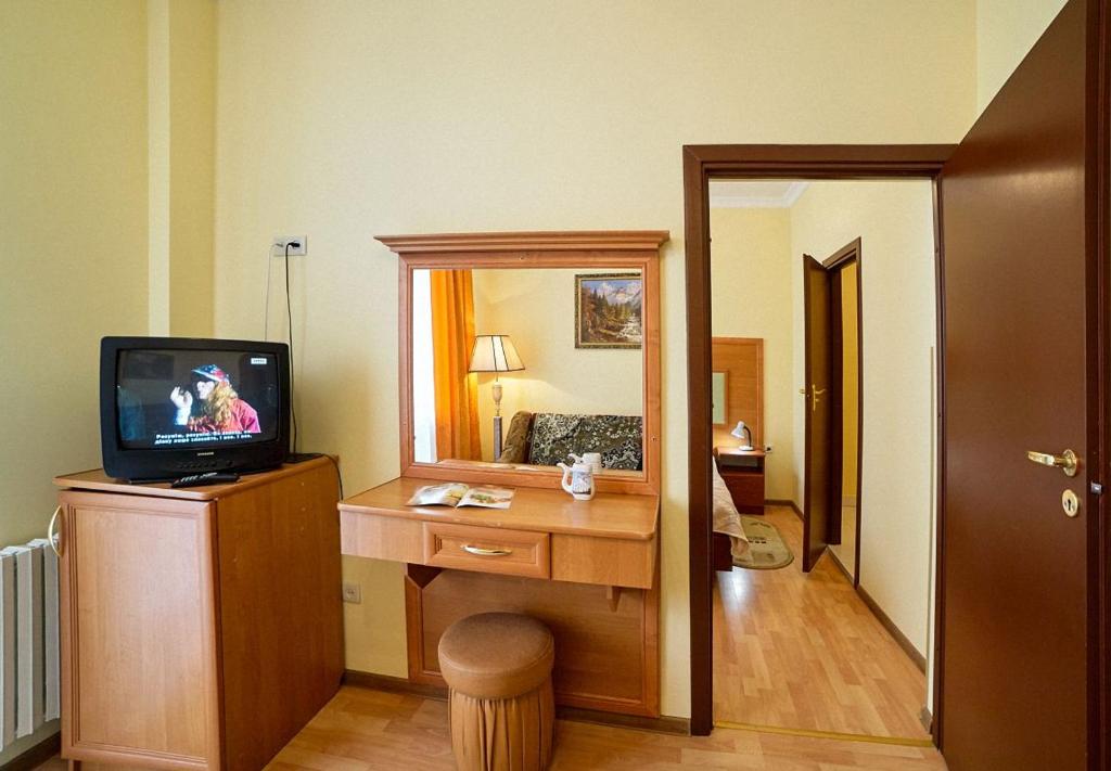een kamer met een televisie en een bureau met een spiegel bij Апартаменти в Готелі в центрі Трускавця - 50 м до центрального бювету in Truskavets