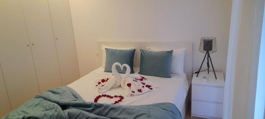 a bed with two pairs of shoes on it at Light Brown Central Apartment in Aveiro