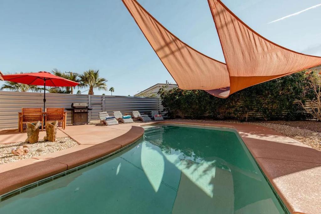 - une piscine avec un parasol et une terrasse dans l'établissement The Yorba Oasis w/Pool, à Palm Springs