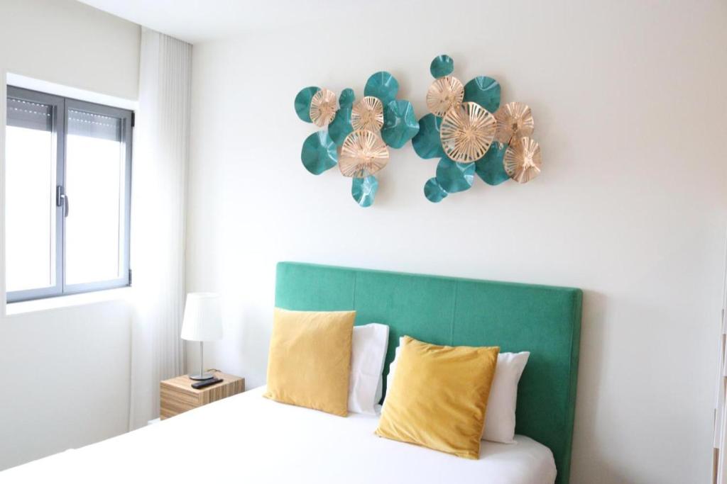 Schlafzimmer mit einem Bett mit einem grünen Kopfteil in der Unterkunft ORM - São Lazaro Apartment in Porto