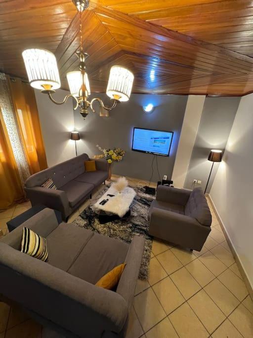 杜阿拉的住宿－AU COEUR DE BONAMOUSSADI-WIFI-PARKING-GARDIENS-24H，客厅配有两张沙发和一台电视机