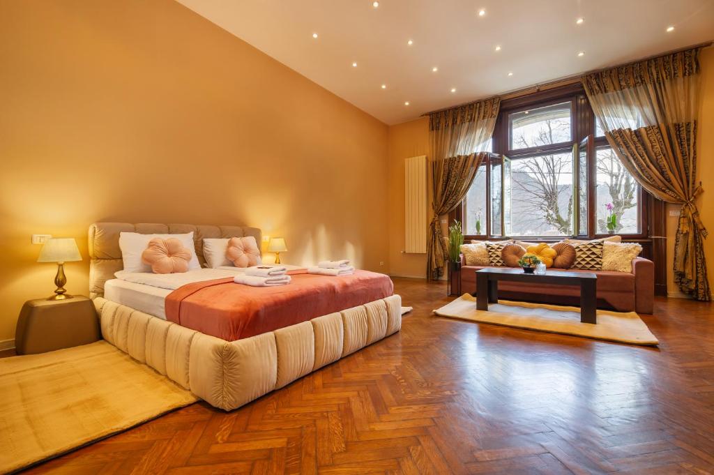 1 dormitorio con 1 cama grande y 1 sofá en Central Park Residence, en Brasov