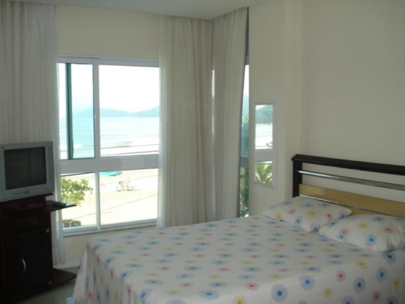 1 dormitorio con 1 cama y vistas a la playa en Apartamento frente mar, en Balneário Camboriú