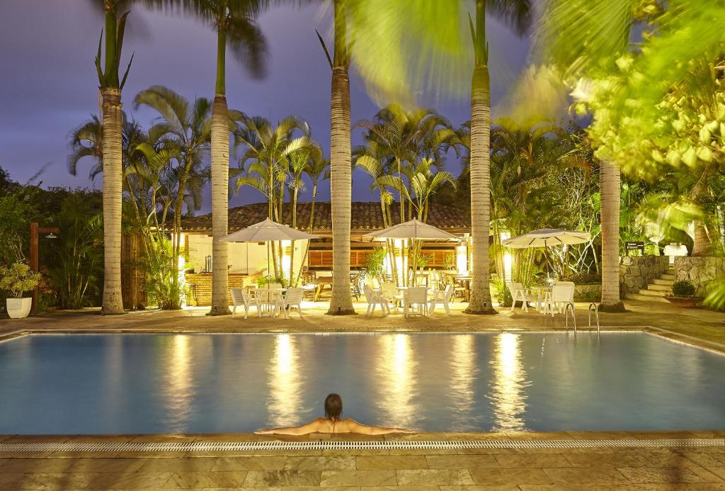 a man laying in a pool in front of a resort at PortoBay Búzios in Búzios