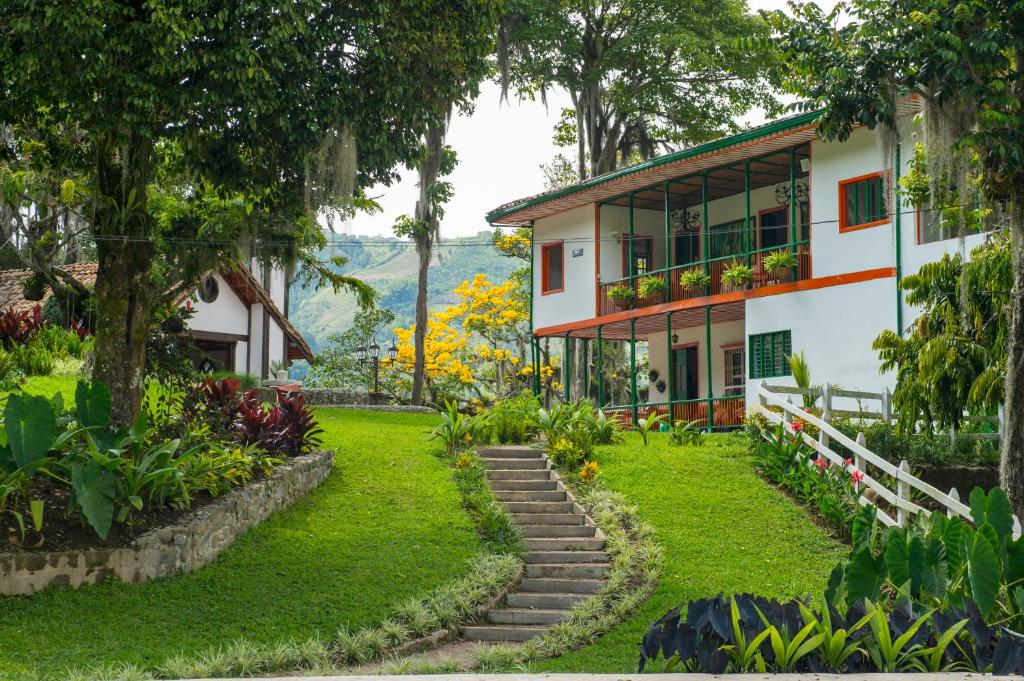 a house with a garden in front of it at Hacienda Charrascal Coffe Farm in Manizales