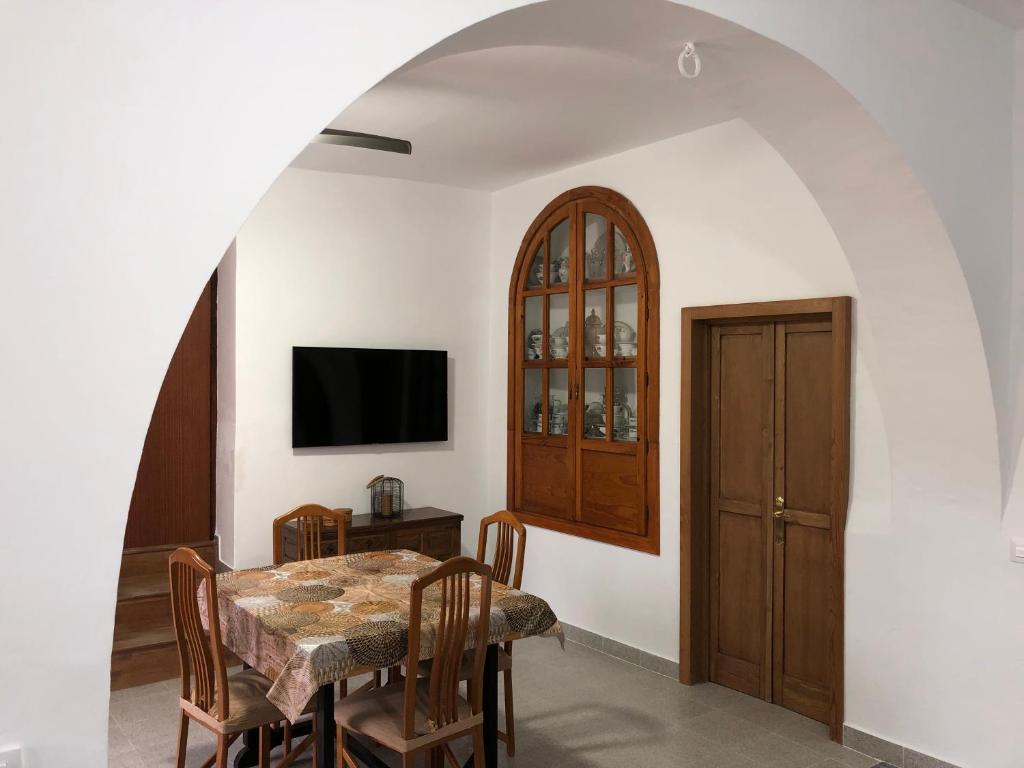a dining room with a table and a tv at Cortijo los Garridos - 7 huéspedes in Almería