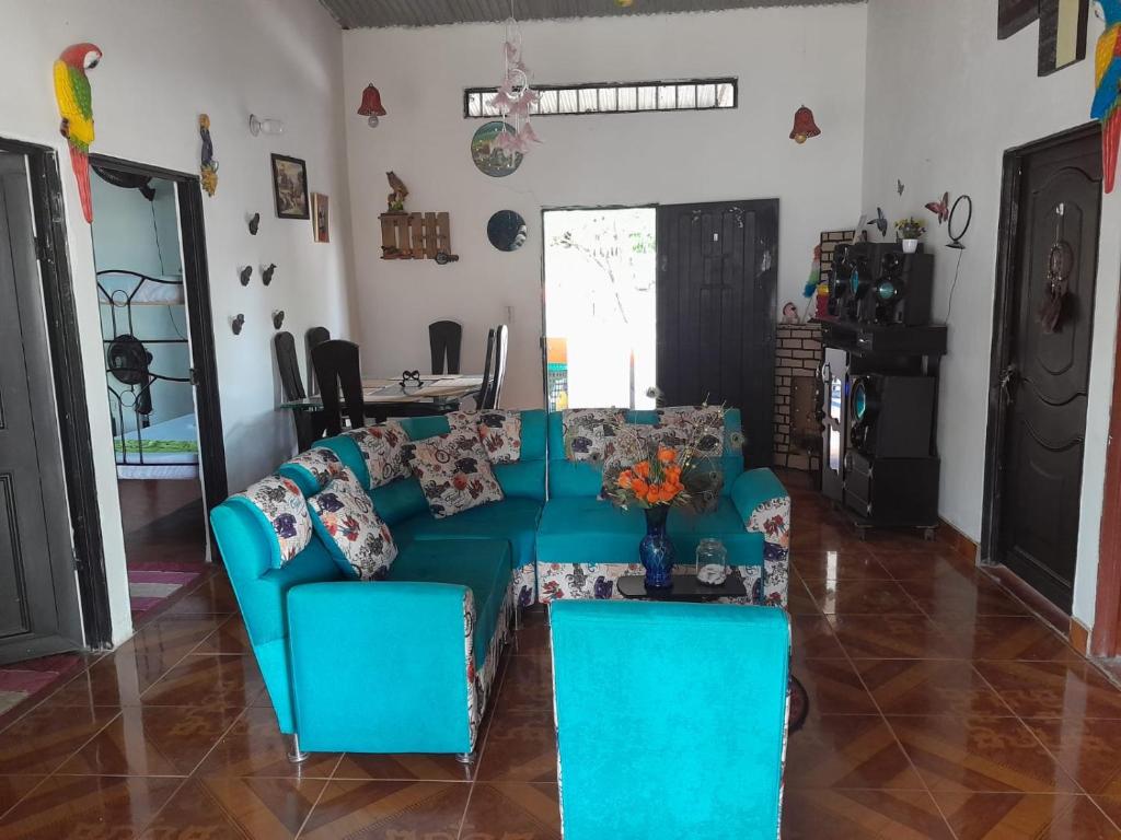 ein Wohnzimmer mit einem blauen Sofa und einem Tisch in der Unterkunft LUNA del DESIERTO TATACOA in Villavieja