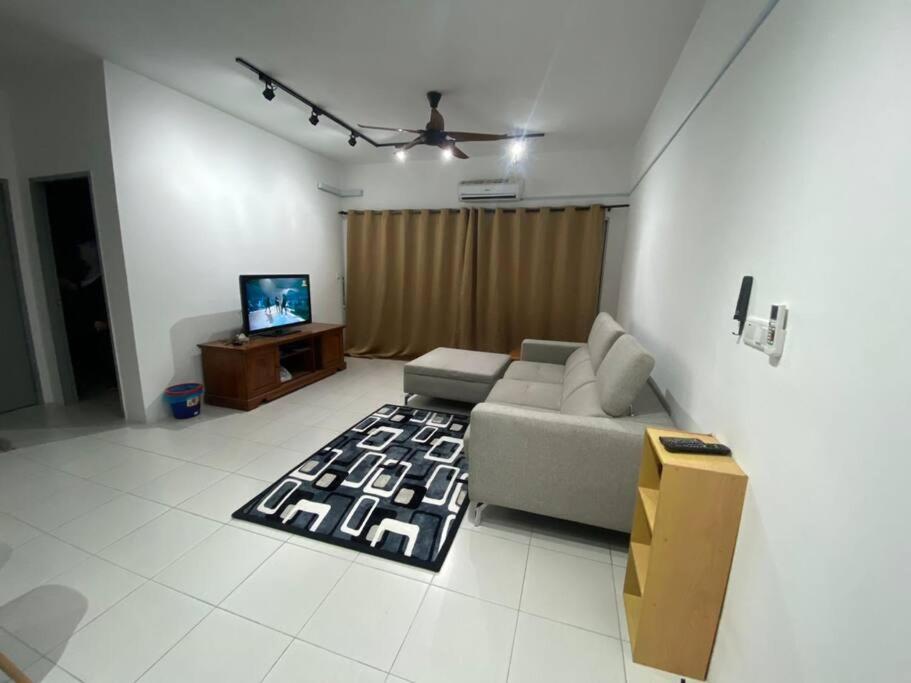 ein Wohnzimmer mit einem Sofa und einem TV in der Unterkunft residensi condominium, taman melati, danau kota, gombak in Kuala Lumpur