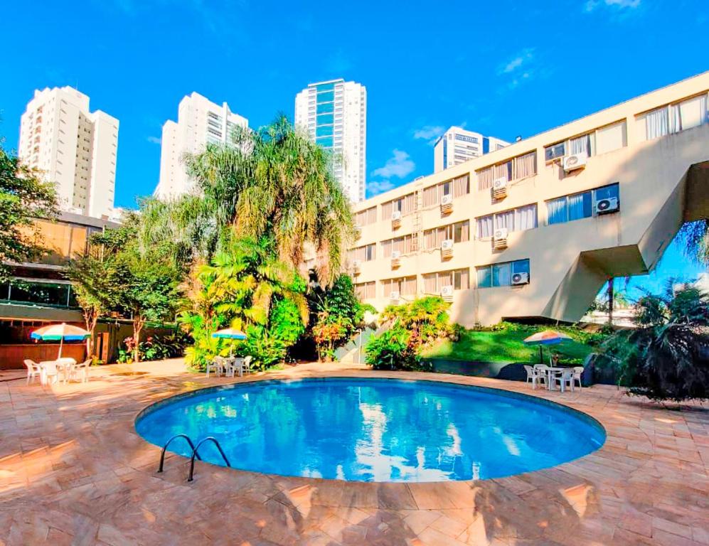 a swimming pool in front of a building at Hotel Harbor Inn Londrina in Londrina