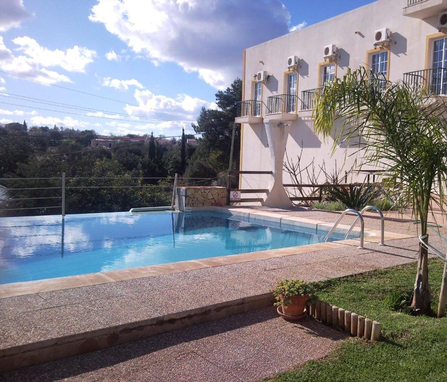 a swimming pool in front of a house at Golda Sol in Loulé