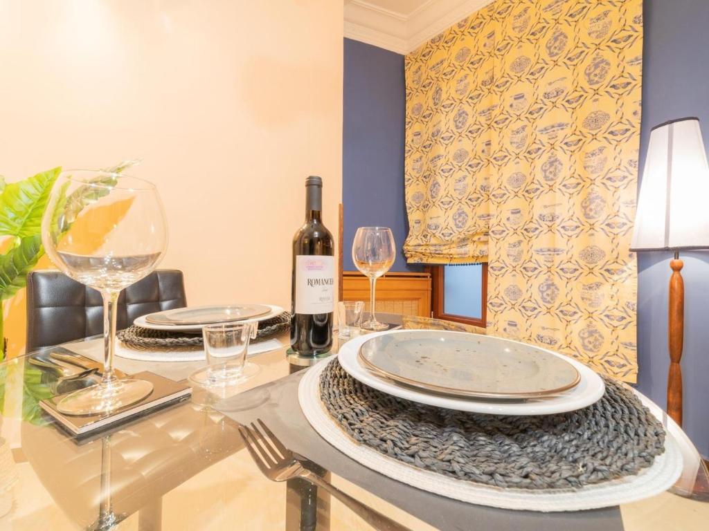 una mesa con dos platos y una botella de vino en Pozas Accommodation by Next Stop Bilbao, en Bilbao