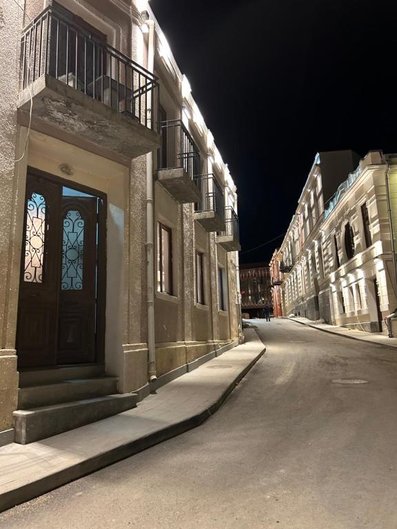 een lege straat 's nachts met een gebouw met een deur bij New House in Old Tbilisi in Tbilisi City