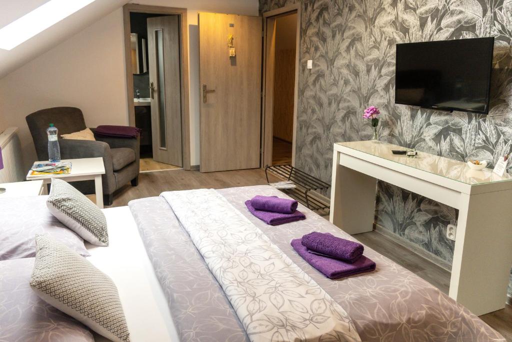 ein Schlafzimmer mit einem Bett mit lila Kissen darauf in der Unterkunft Privat Nisa in Nová Lesná