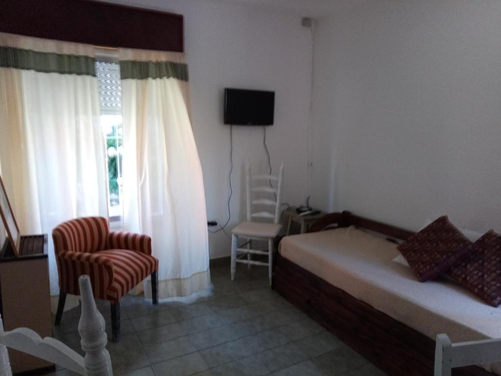 1 dormitorio con 1 cama, 1 silla y 1 ventana en Lo de Normi en Tandil