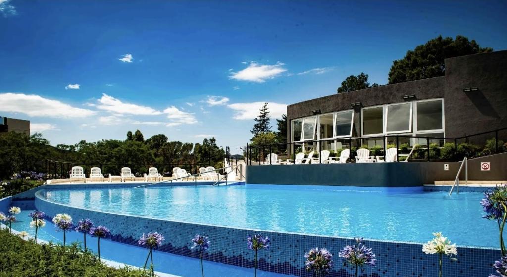 una gran piscina con sillas y un edificio en VENETO VILLAGE en Villa Carlos Paz