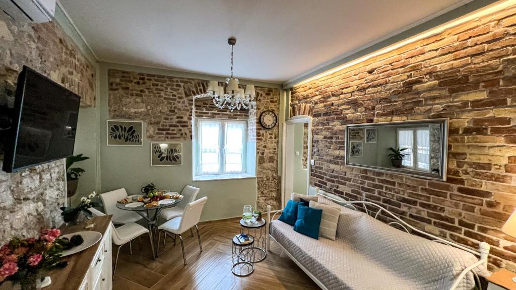 ein Wohnzimmer mit Ziegelwand in der Unterkunft Bruskos luxury in Korfu-Stadt