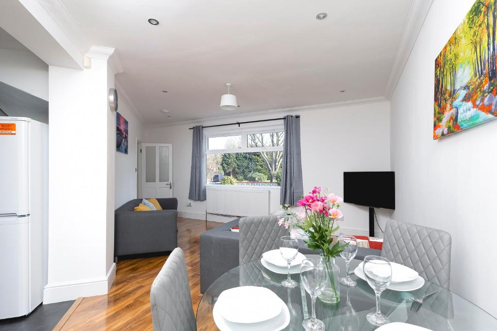 a dining room and living room with a table and chairs at Skyvillion - London Enfield 4 Bedroom Lush House Free Parking Garden in Enfield Lock