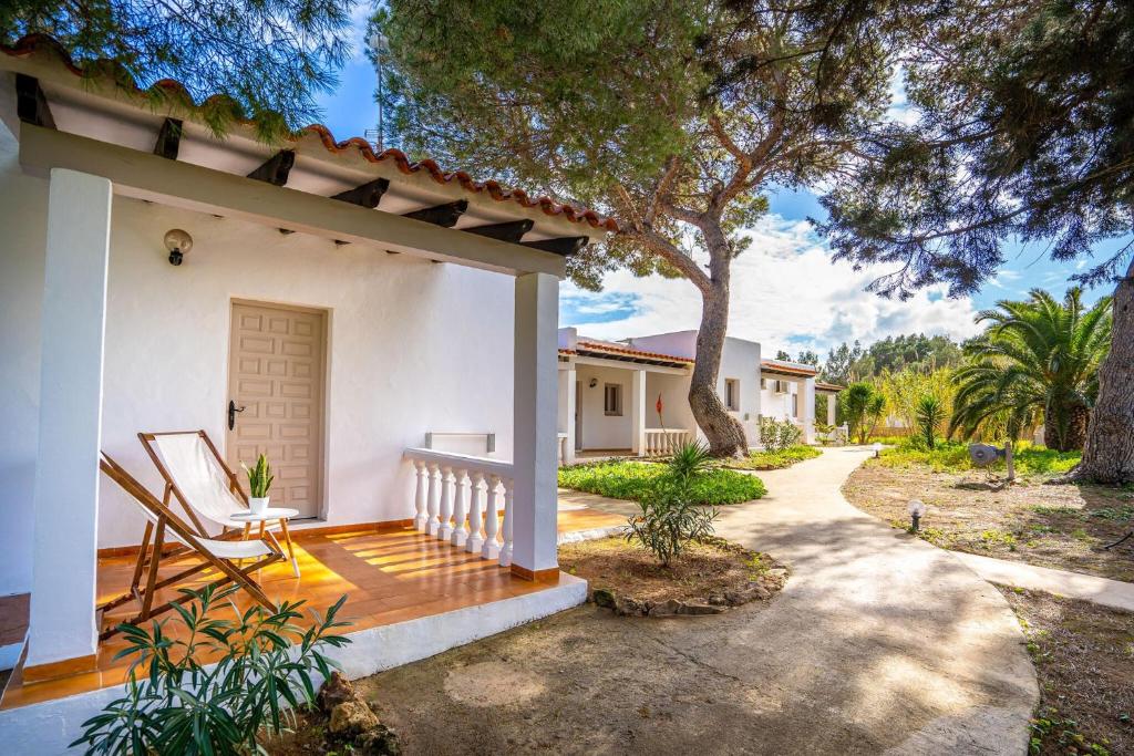 ein weißes Haus mit einer Veranda und einem Baum in der Unterkunft Viviendas turísticas Lesley VTV Es Pi - Formentera Break in Playa Migjorn