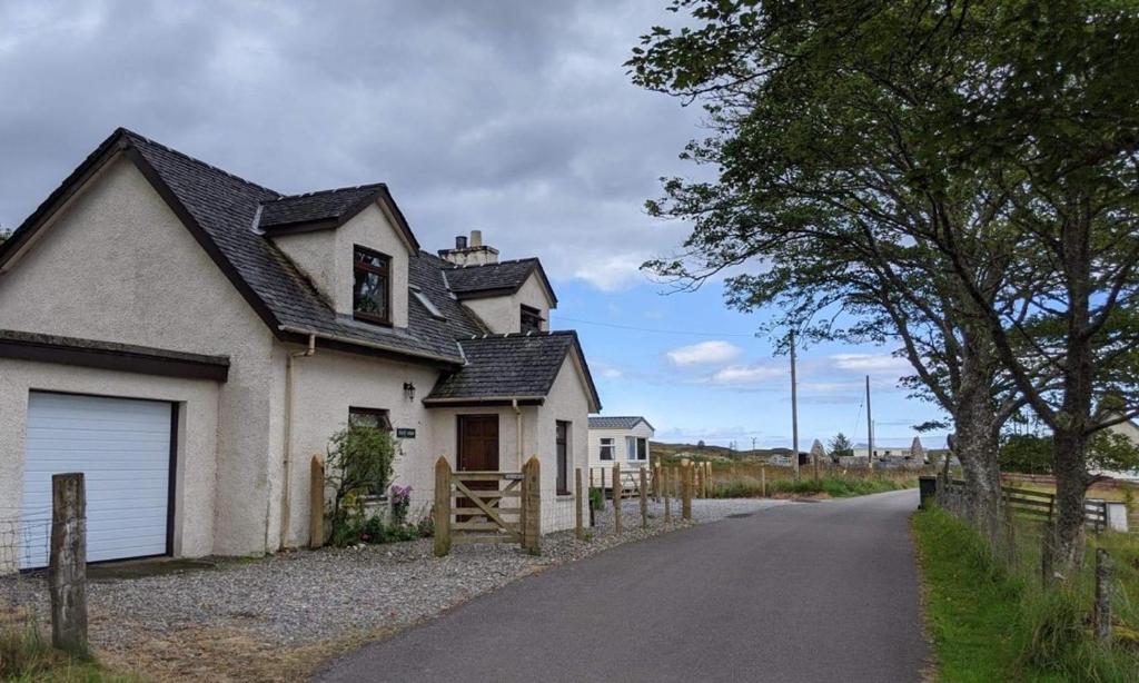 a white house with a fence and a road at Arisaig B&B Lovely Double Room Sea & Island Views in Arisaig