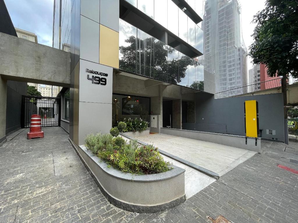 un edificio con un patio con plantas delante de él en Condomínio de studios completos por temporada na Av. Rebouças, en São Paulo