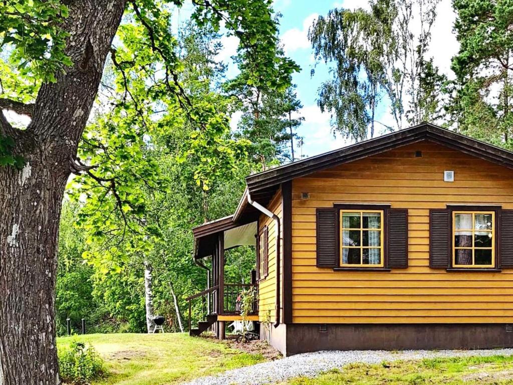 ein kleines Holzhaus mit einem Baum daneben in der Unterkunft Holiday home VITTBOLANDET 