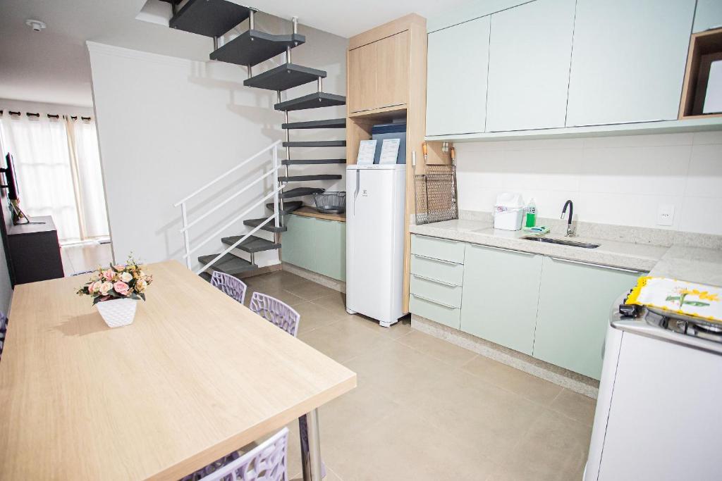 Una cocina con gabinetes blancos y una encimera de madera. en Completa casa apenas 700m da praia, en Itajubá