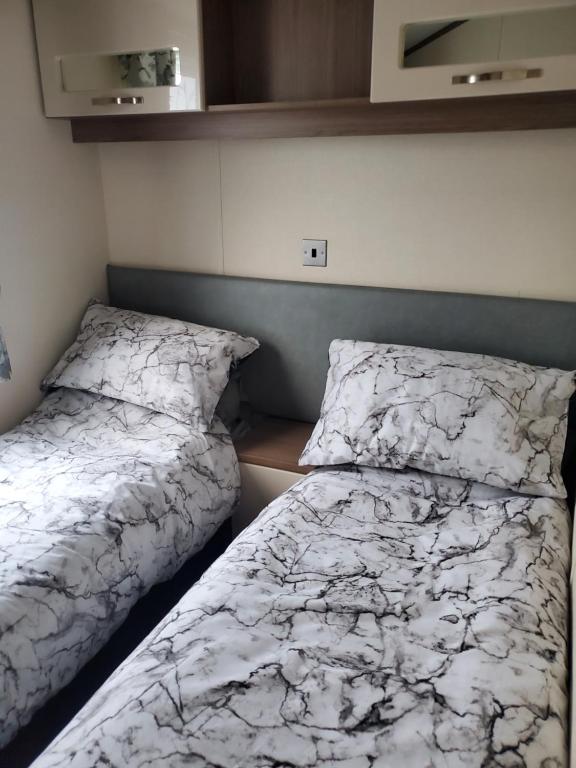 dos camas sentadas una al lado de la otra en un dormitorio en Heysham seaview, en Heysham