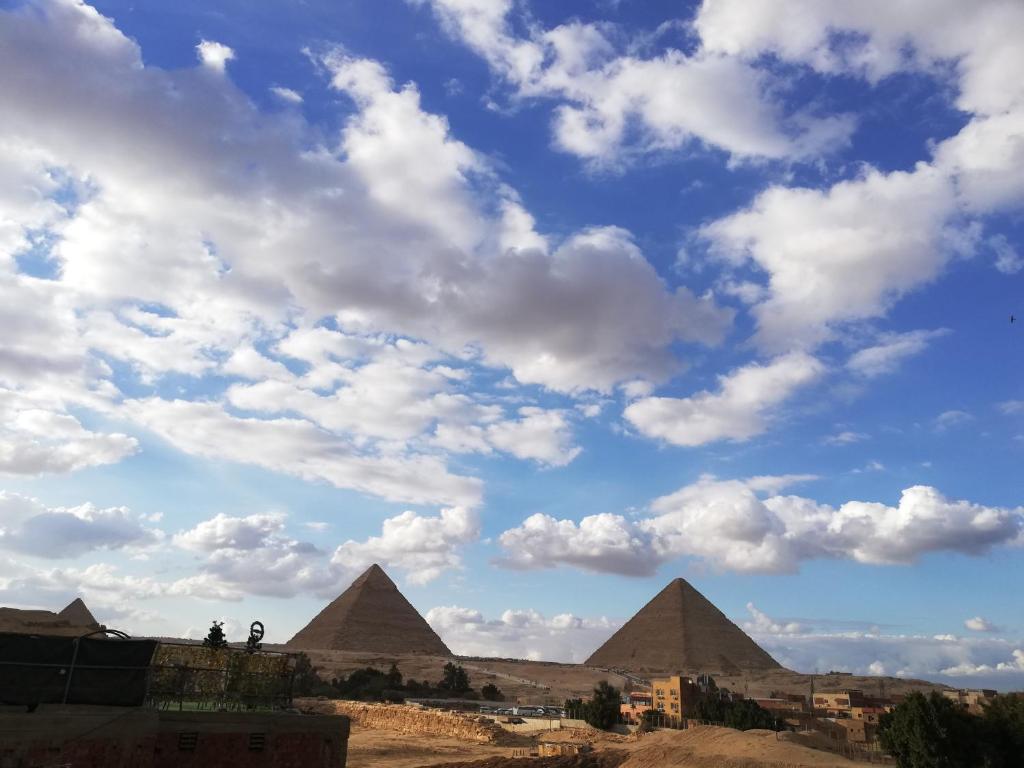 einen Blick auf die Pyramiden unter einem wolkigen Himmel in der Unterkunft Capo Pyramid in Kairo